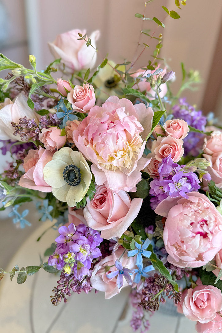Close-up of baby pink peonies, O'Hara roses, anemones, stock and lilacs