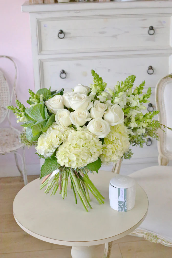 All-white rose, hydrangea and snapdragon bouquet with cabbage roses in premium wrapping