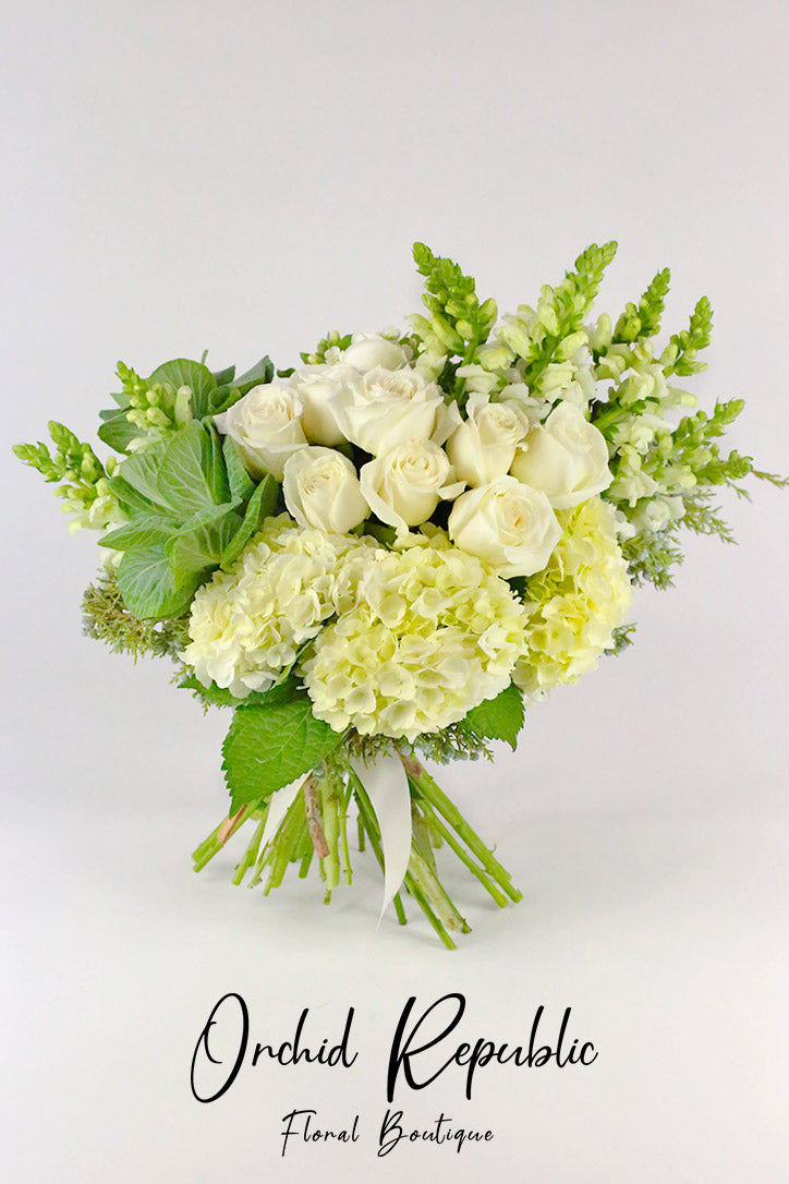 Full all-white hand bouquet showing layered fine paper and decorative ribbon