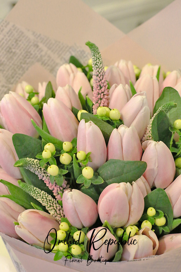 Close-up of blush tulips, pink veronica and clusters of white hypericum berries