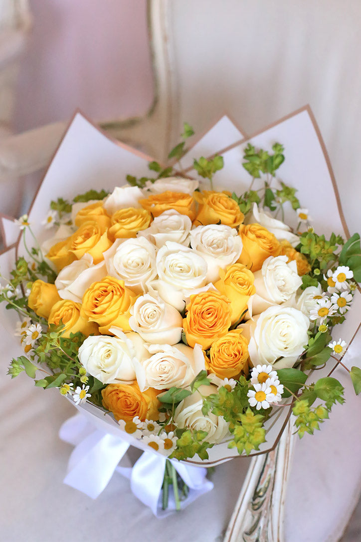 Close-up of yellow roses, white roses and charming daisy blooms