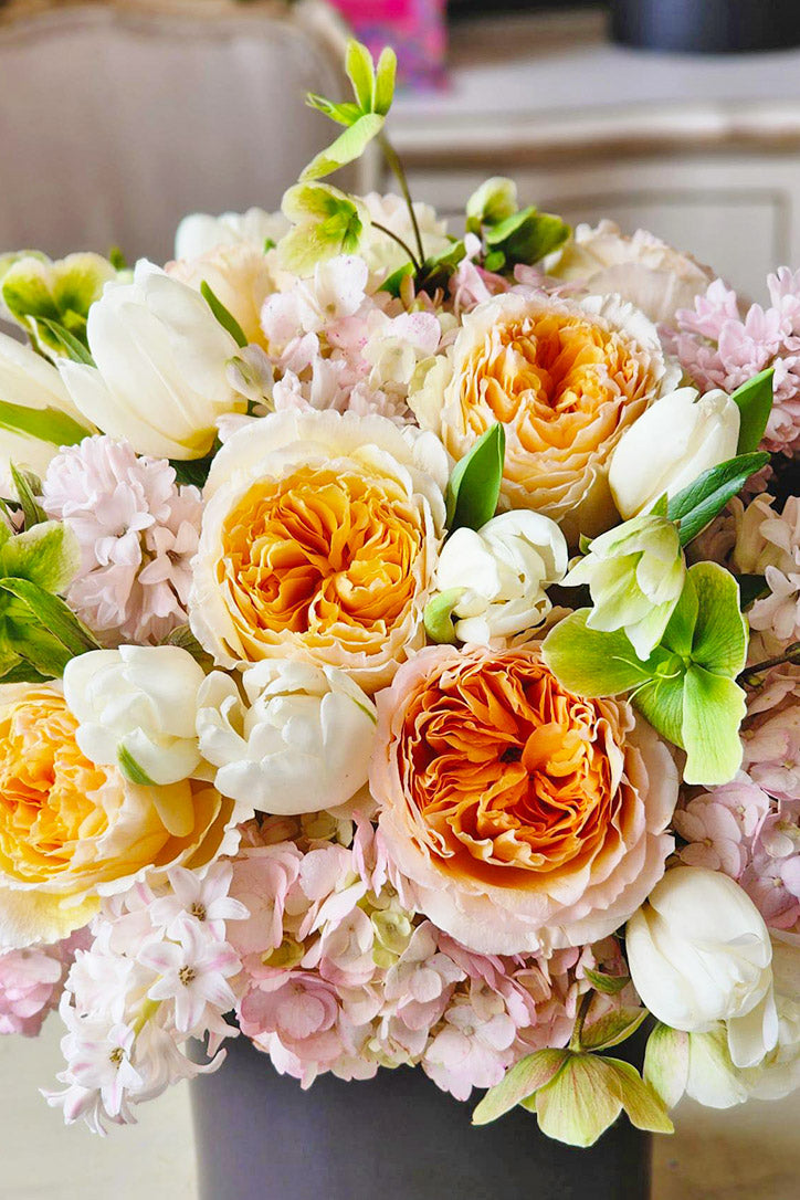 Close-up of peach roses, white tulips, hyacinths, hydrangeas and green hellebores