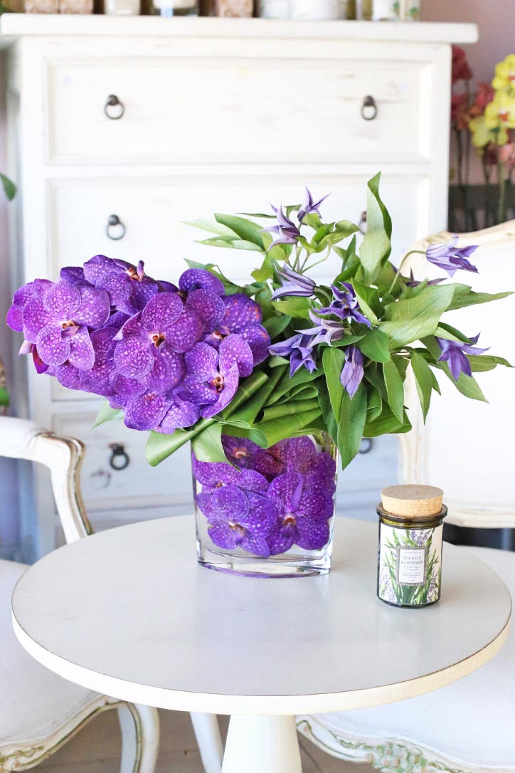 Purple Vanda orchids and clematis arranged in a sculptural luxury floral design