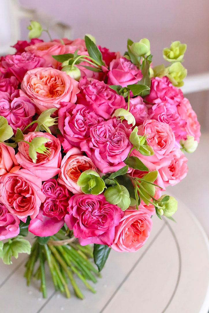 Close-up of pastel pink Xpression and mauve Country Blues roses with green hellebores