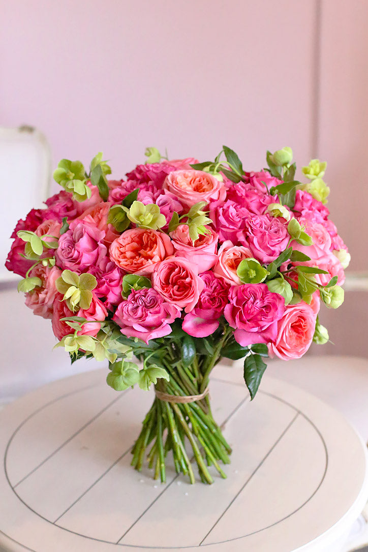 Close-up of pastel pink Xpression and mauve Country Blues roses with green hellebores