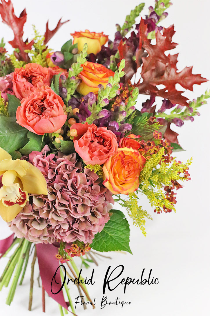 Close-up of cymbidium orchids, orange roses, mauve snapdragons and hydrangeas
