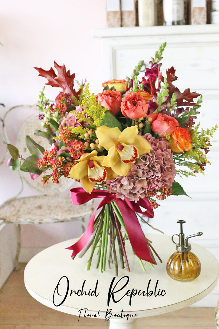 Golden orchid and orange rose bouquet with hydrangeas and snapdragons