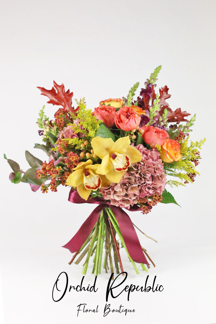 Golden orchid and orange rose bouquet with hydrangeas and snapdragons