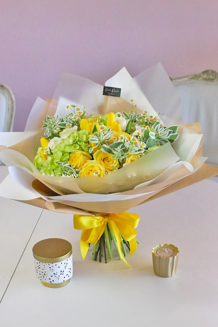 Rose, tulip and hydrangea hand bouquet with fresh foliage in fine paper