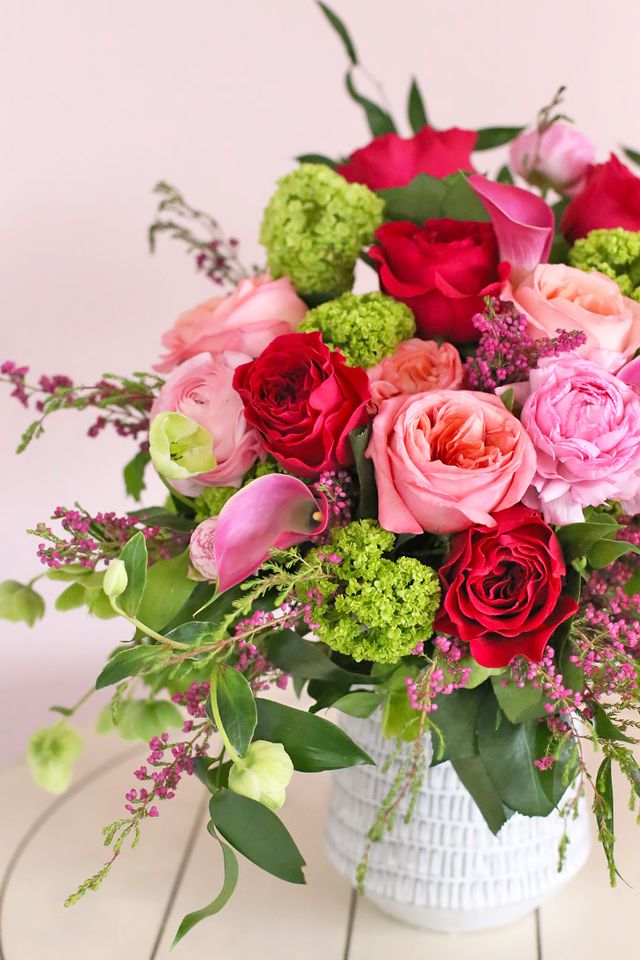 Close-up of Pink Expression, red and hot pink roses with callas and green viburnum