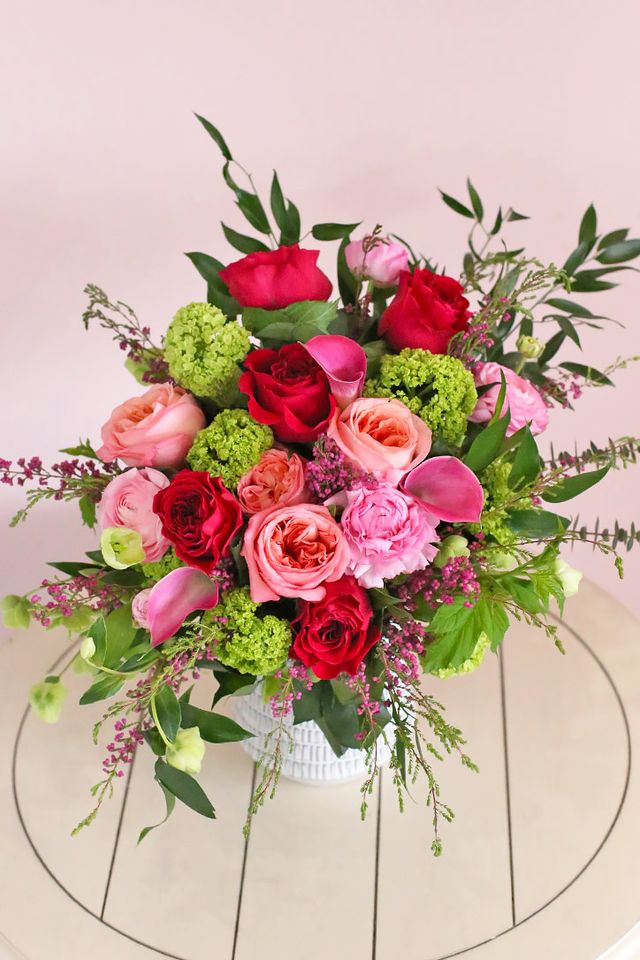 Close-up of Pink Expression, red and hot pink roses with callas and green viburnum