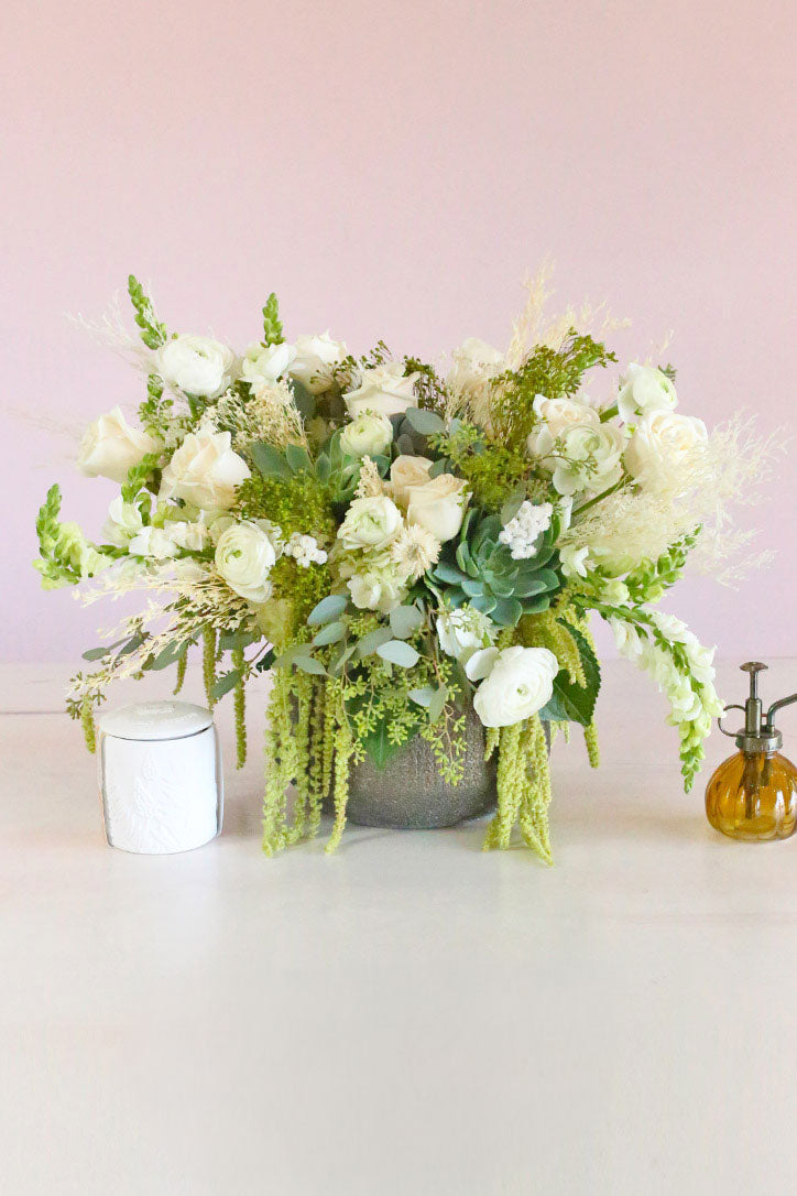 White roses, ranunculus and snapdragons with succulents and trailing amaranthus