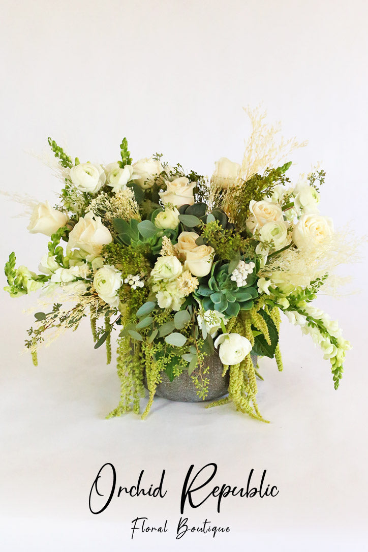 White roses, ranunculus and snapdragons with succulents and trailing amaranthus