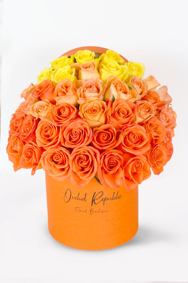 Gradient orange, peach and yellow rose arrangement in a luxury hat box