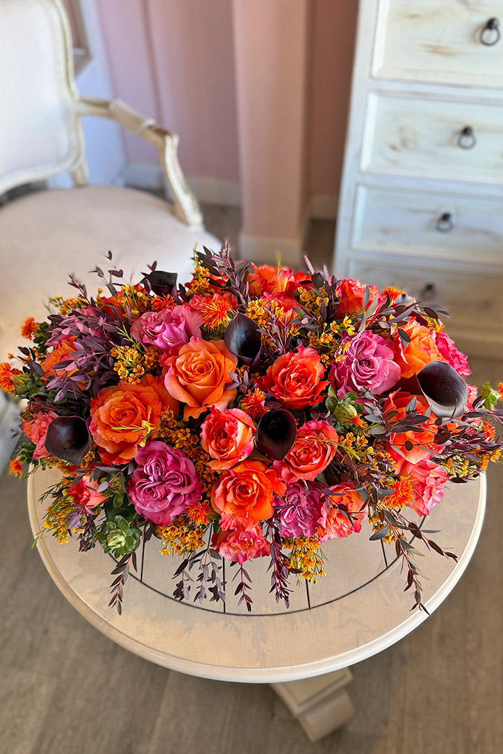 Orange Free Spirit and mauve Country Blue rose centerpiece with black calla lilies