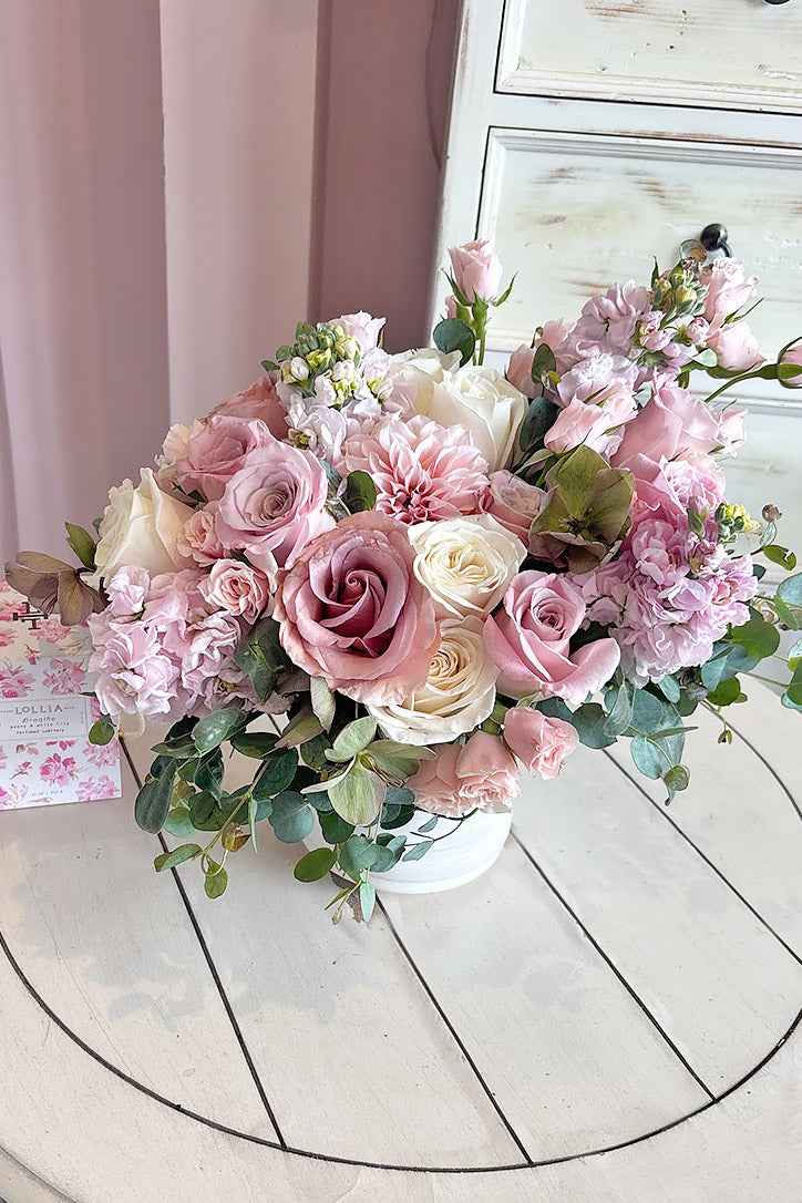 Close-up of baby pink dahlias, dusty pink spray roses and cream roses