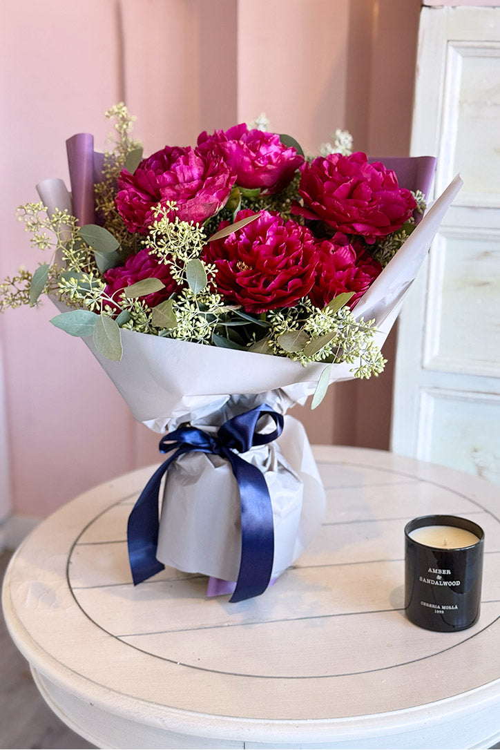 Berry pink peony bouquet with seeded eucalyptus in silvery fine paper wrapping